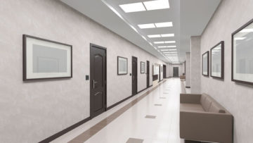 Interior corridor of office space with doors and a sofa